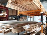 many wooden planks stacked on a rack in a warehouse