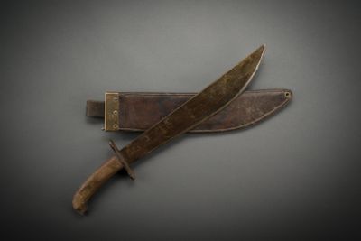 an old knife with a wooden handle sitting on top of a table