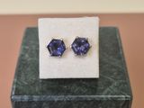 a pair of blue sapphire earrings sitting on top of a marble block