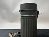 an old metal trash can with a strap around it on a black surface