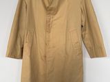 a tan trench coat hanging on a hanger on a wall