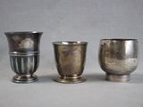 three silver cups sitting next to each other on a table