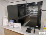 un grand téléviseur à écran plat posé sur un comptoir dans un magasin