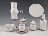 a group of white dishes and cups on a table