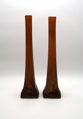 deux vases bruns posés l'un à côté de l'autre sur une surface blanche