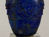 a blue vase with a lid sitting on a clear stand