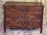 a wooden chest of drawers with ornate carvings on it