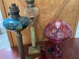 trois vases en verre et une lampe posés sur une table en bois