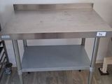 a table with a shelf on it in the corner of a room