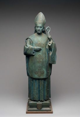 bronze statue of a priest holding a staff and a staff