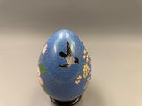 a blue egg with a bird painted on it