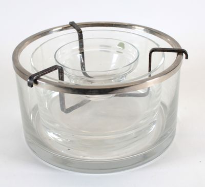 un récipient en verre transparent muni d'une poignée métallique, posé sur une surface blanche