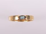 gros plan d'une bague en or avec une pierre bleue