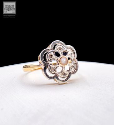 a close up of a gold ring with pearls on a white surface