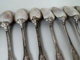 six silver spoons are lined up in a row on a table