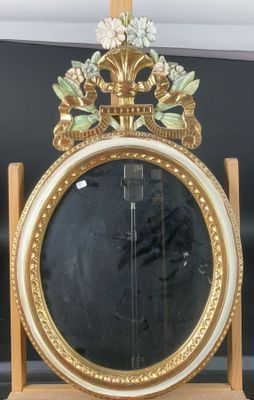 un miroir avec un cadre doré et un miroir orné de fleurs