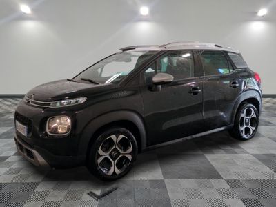 la voiture noire est garée sur un sol en damier dans le garage
