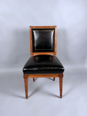 une image représentant une chaise avec une assise en cuir noir sur fond blanc