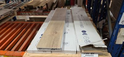plusieurs pièces de bois sont empilées sur des palettes dans un entrepôt