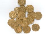 une pile de pièces d'or posée sur une surface blanche
