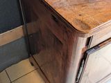 a wooden cabinet in the corner of a bathroom