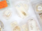 many different types of jewelry in plastic containers on the table