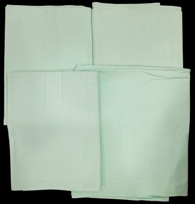 four folded white napkins on a black background