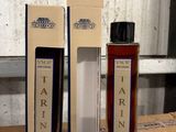two bottles of tarin sit on a wooden table next to boxes