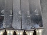 four knives are lined up on a table with a knife holder