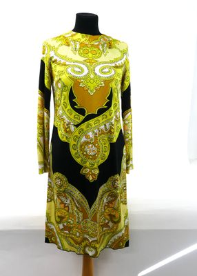 yellow and black dress on a mannequin stand in front of a window