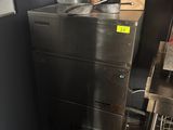 a metal cabinet in the corner of a kitchen with pots and pans on top of it