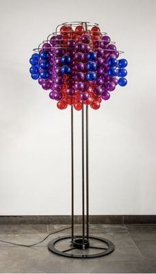 a large multicolored lamp on a metal stand with a black base