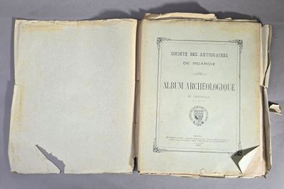 un vieux livre ouvert, dévoilant une page de texte sur une surface grise