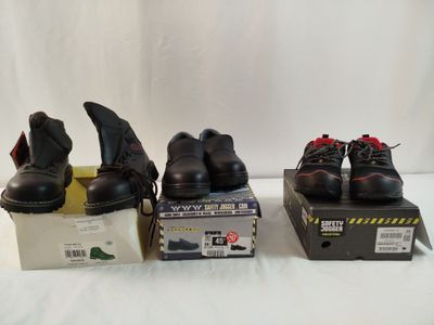 three pairs of black work boots sitting on top of a box