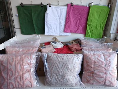 de nombreux sacs de vêtements posés sur une étagère dans une pièce