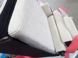 un tas de vêtements et de couvertures dans une charrette garée dans la rue