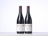 two bottles of red wine sitting on top of a table