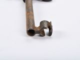an old rusty key that is laying on a white surface