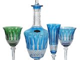 a blue glass decanter and wine glasses next to each other