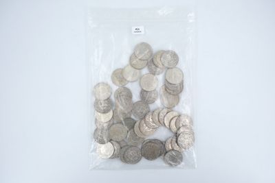 un sac rempli de pièces d'argent posé sur une surface blanche