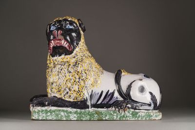 statue of a pug dog on a green base with a black and white background