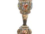 a vase that is sitting on a stand on a white surface