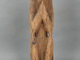 une vieille statue en bois représentant un homme les mains croisées