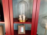 a red cabinet with a glass door and pictures on it