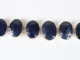 a close up of a row of blue stones on a white surface