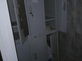 une armoire située dans un coin de la salle de bains, équipée d'un miroir