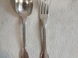 deux cuillères en argent et une fourchette posées sur une nappe blanche