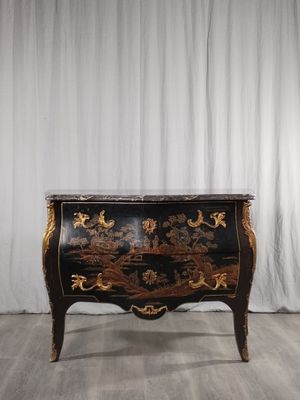 an image of a black and gold chest of drawers on a wooden floor