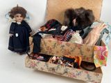 a doll standing next to a suitcase full of clothes