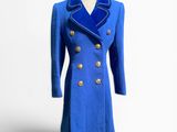 manteau en laine bleue avec des boutons dorés, posé sur un socle de mannequin